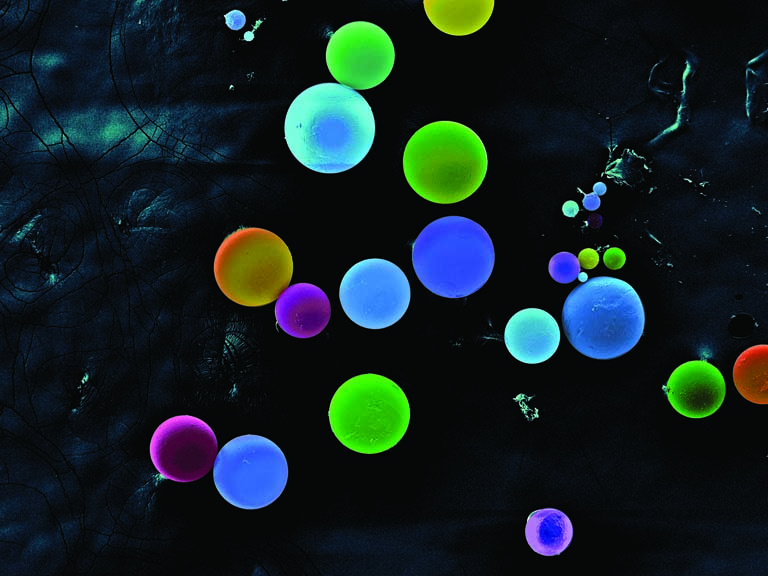 fluorescently colored spheres in pale shades of blue and green