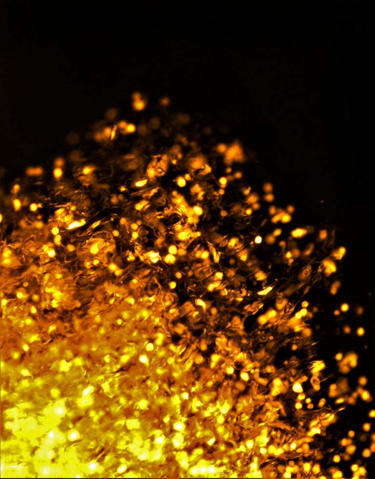 cells (in gold) disperse upward against a black background